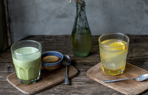 matcha latte and hot water and lemon on a wooden table with flowers 